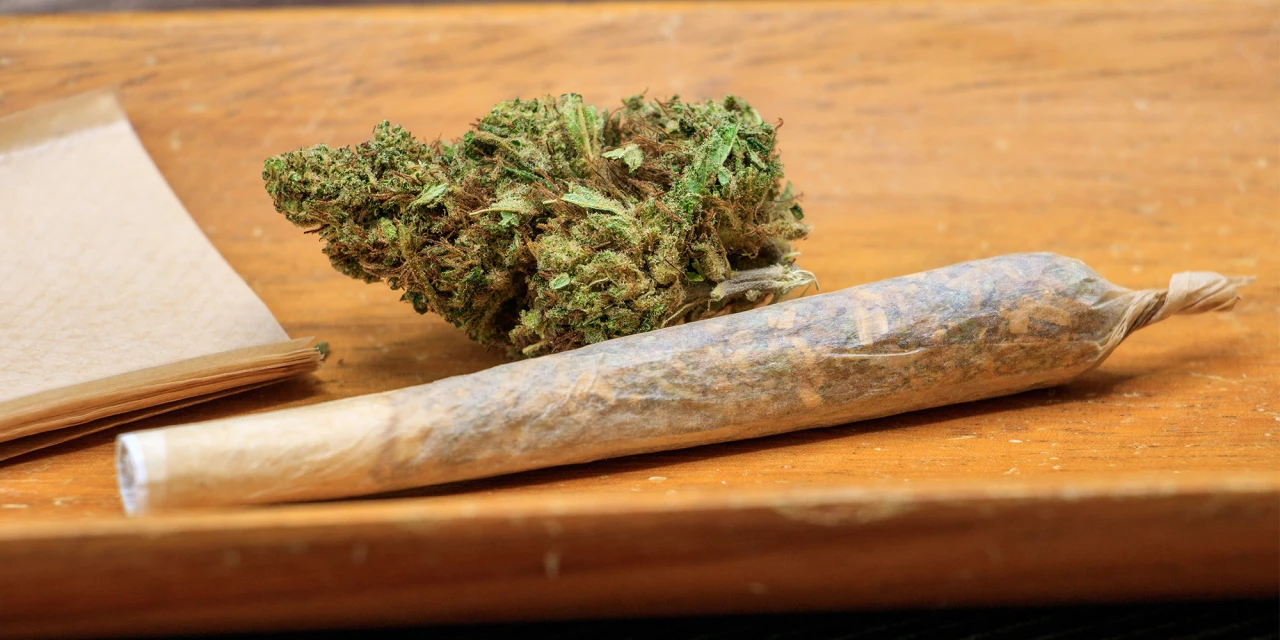 Close-up van een joint en wiettop op tafel, passend bij de gevolgen van blowen en cannabisgebruik.