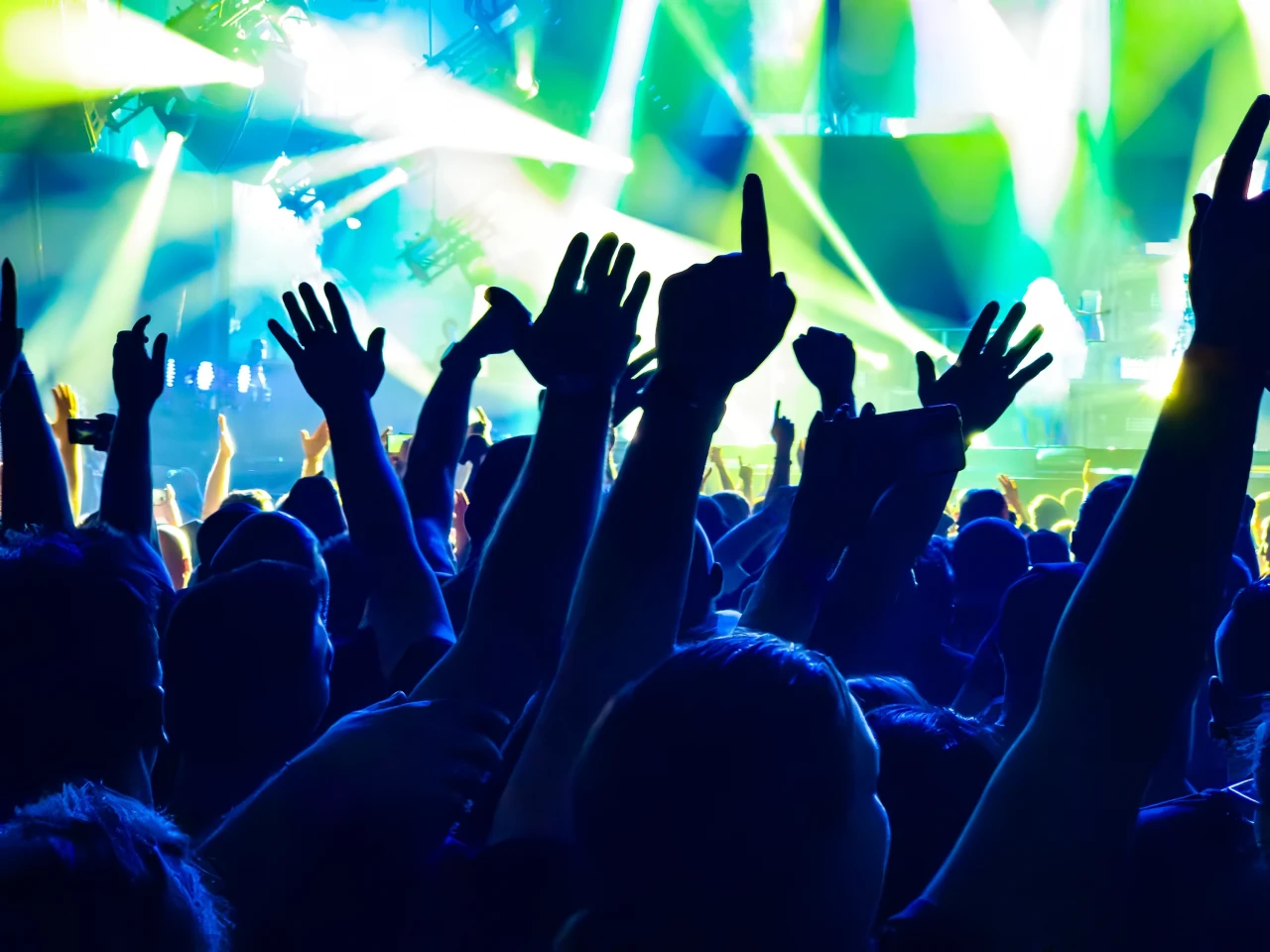 feestend-publiek Feestende mensen tijdens het uitgaan met de handen omhoog in een club.