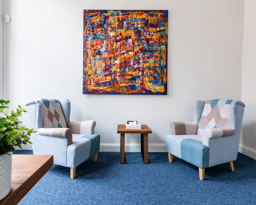 Twee comfortabele stoelen staan tegenover elkaar in een rustige ruimte binnen een afkickkliniek in Utrecht.