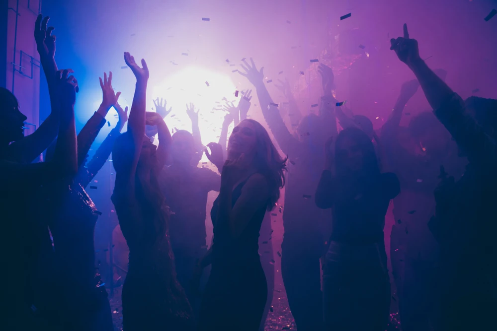 dansende-mensen-in-club Feestende, dansende mensen die zich nog geen zorgen maken over waarom alcohol verslavend is.