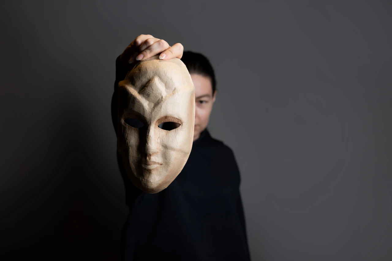 Vrouw houdt masker half voor gezicht wat figuurlijk toont hoe lastig een wietroker te herkennen is.