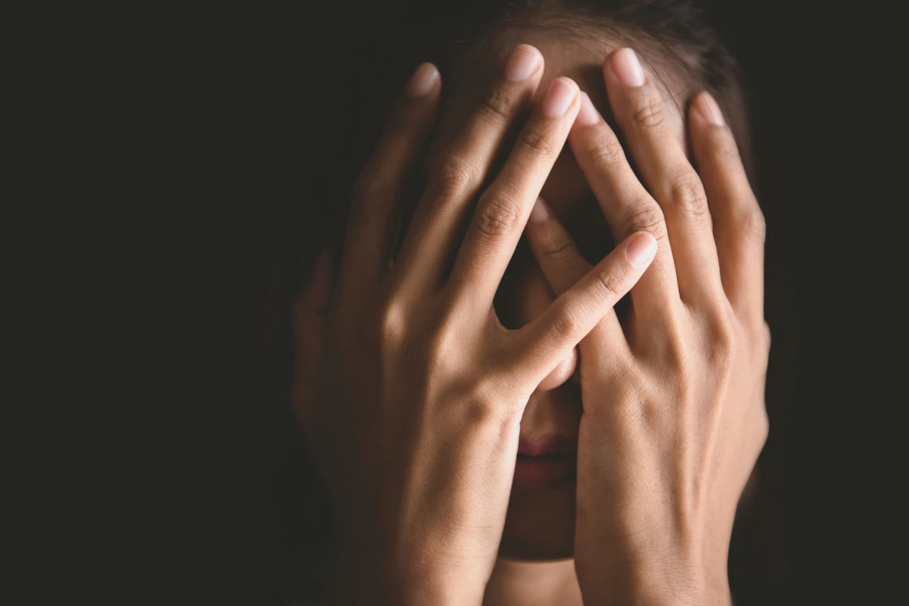 vrouw-verbergt-gezicht Vrouw verbergt gezicht met de handen.
