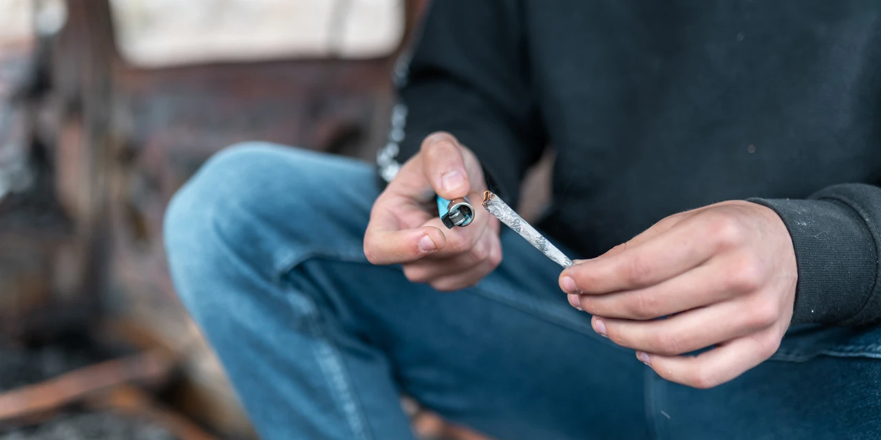 Persoon steekt een joint aan tijdens het blowen, passend bij klachten en afkickverschijnselen van wiet blowen.