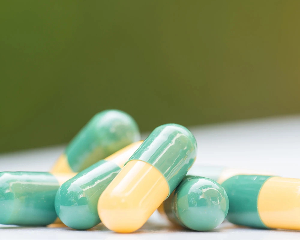 Close-up van meerdere tramadol capsules op een lichte ondergrond. De afbeelding verwijst naar medicatiegebruik en de risico’s van een tramadol verslaving.