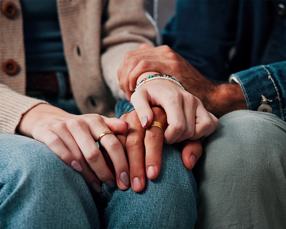 Partners houden elkaars handen vast en geven steun aan elkaar.