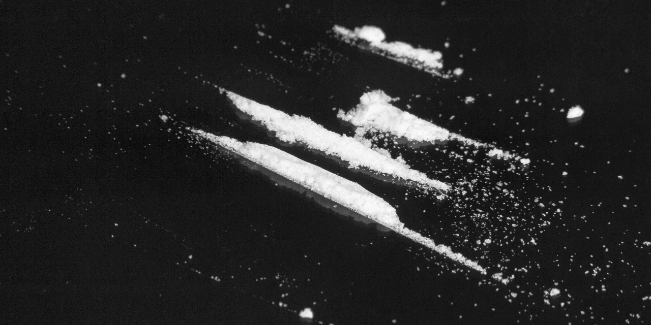 Lijnen cocaïne op een zwarte ondergrond, passend bij cocaïnegebruik en cold turkey stoppen met coke.