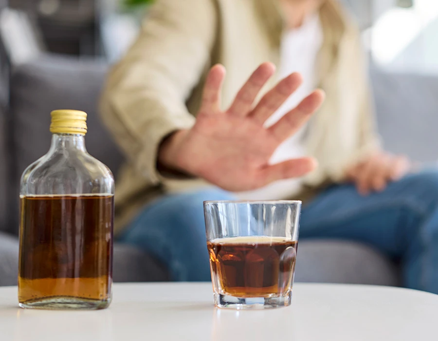 Persoon houdt afstand van alcohol tijdens een detox alcohol traject binnen de verslavingszorg.