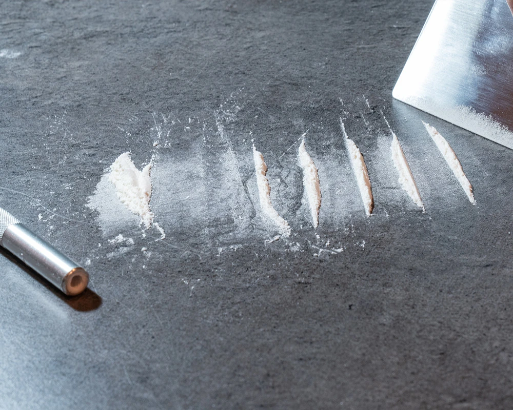 Gedrag van een verslaafde met drugslijnen en opgerold briefje.