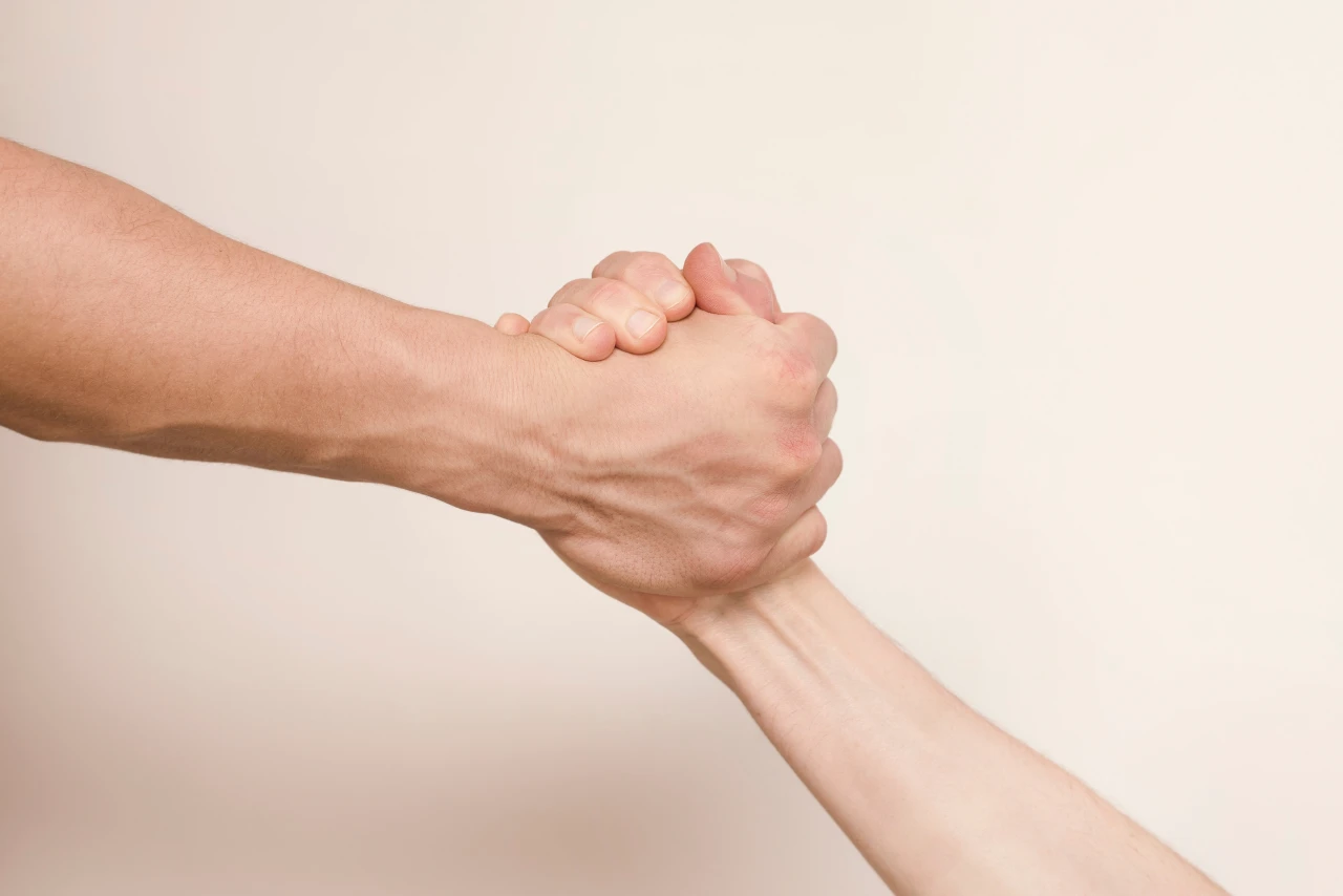 Twee-handen-houden-elkaar-vast Hand houdt andere vast om steun te bieden bij afkickverschijnselen van ketamineverslaving.