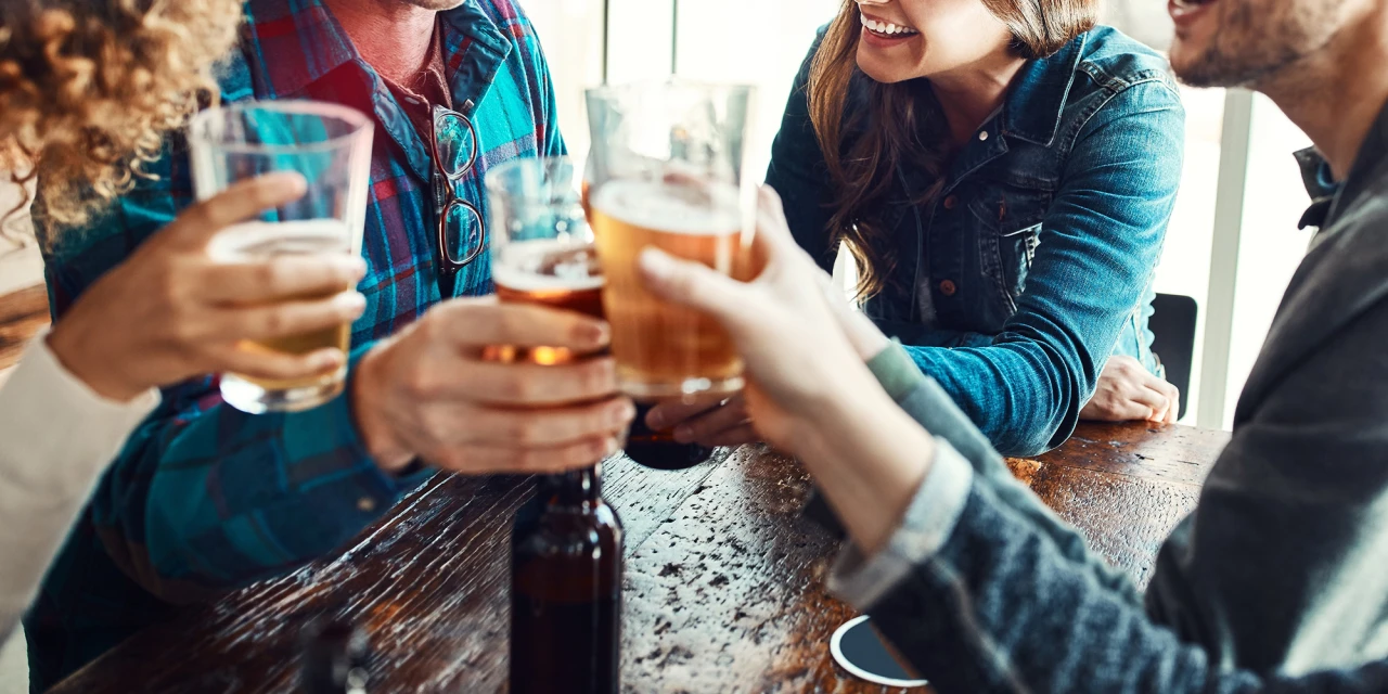 Een groep mensen drinkt samen alcohol tijdens een sociaal moment in een café.