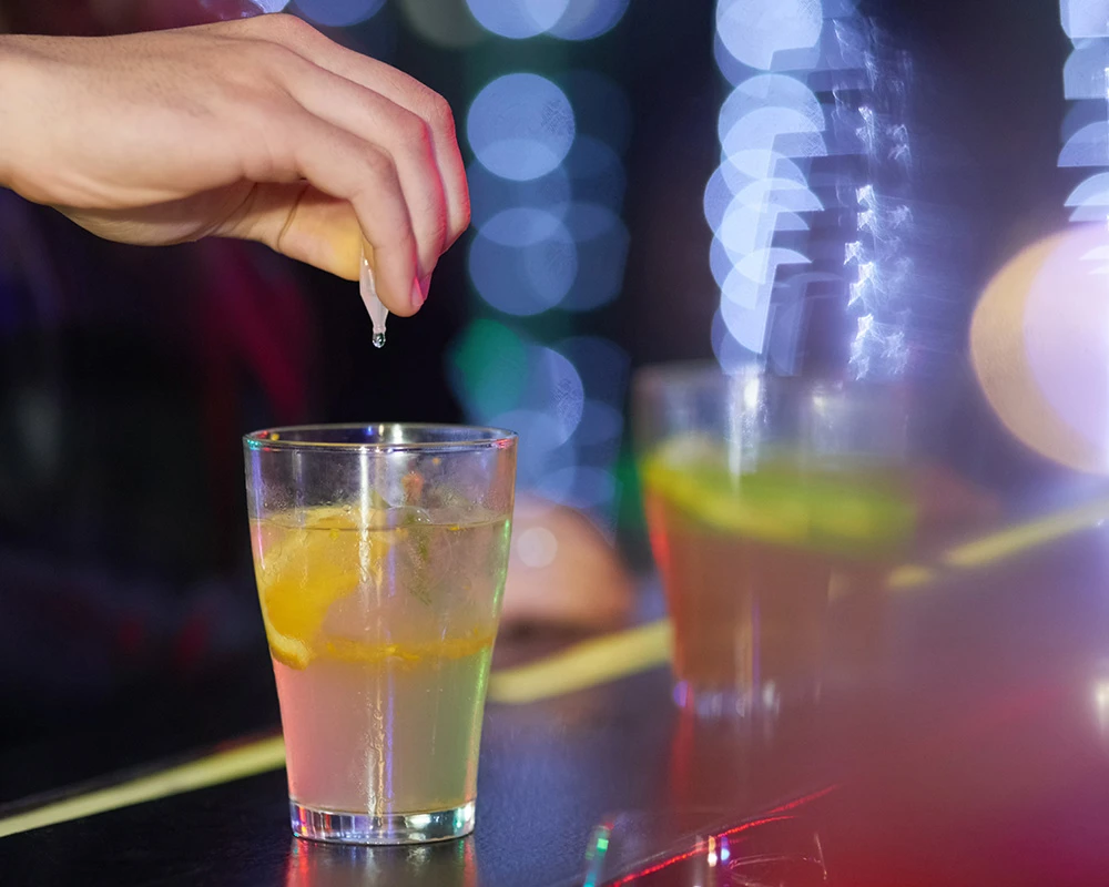 Spiking: druppels worden ongemerkt aan een drankje in een bar toegevoegd.