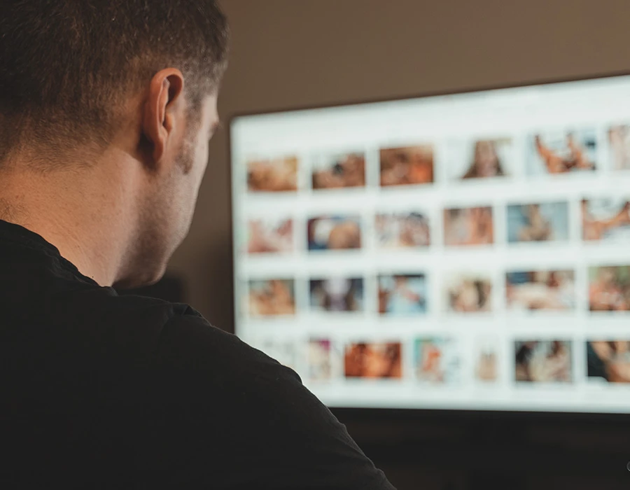 Man kijkt naar pornografische beelden op een computerscherm.