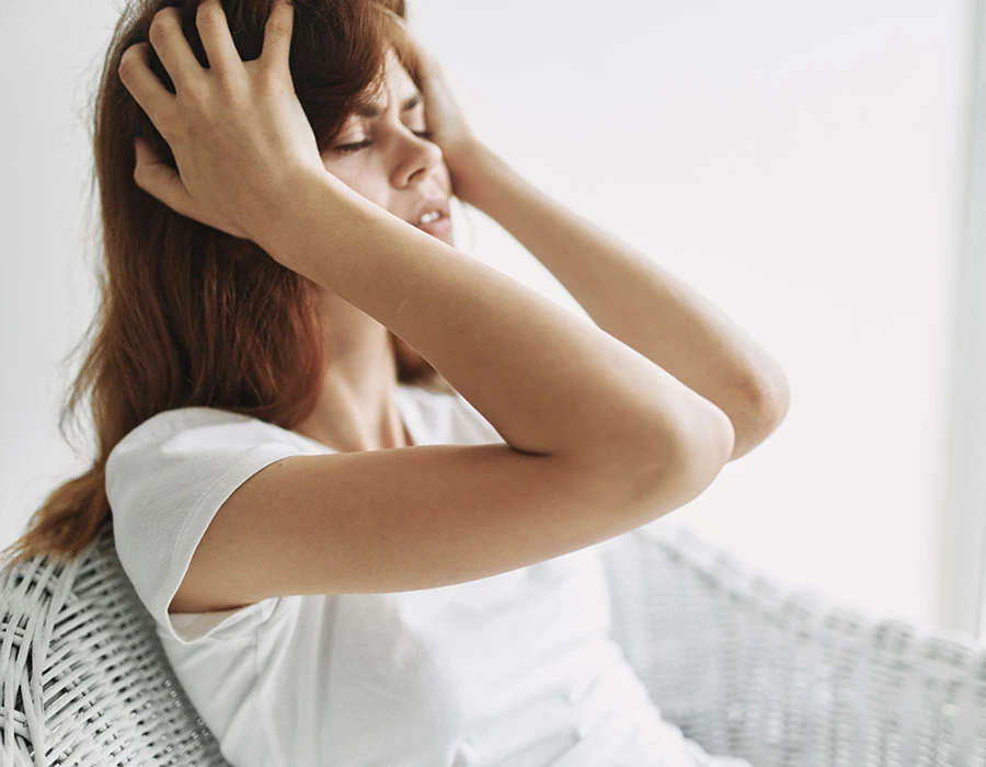 Vrouw met hoofdpijn en stress, illustratie van dubbeldiagnostiek en mentale klachten.
