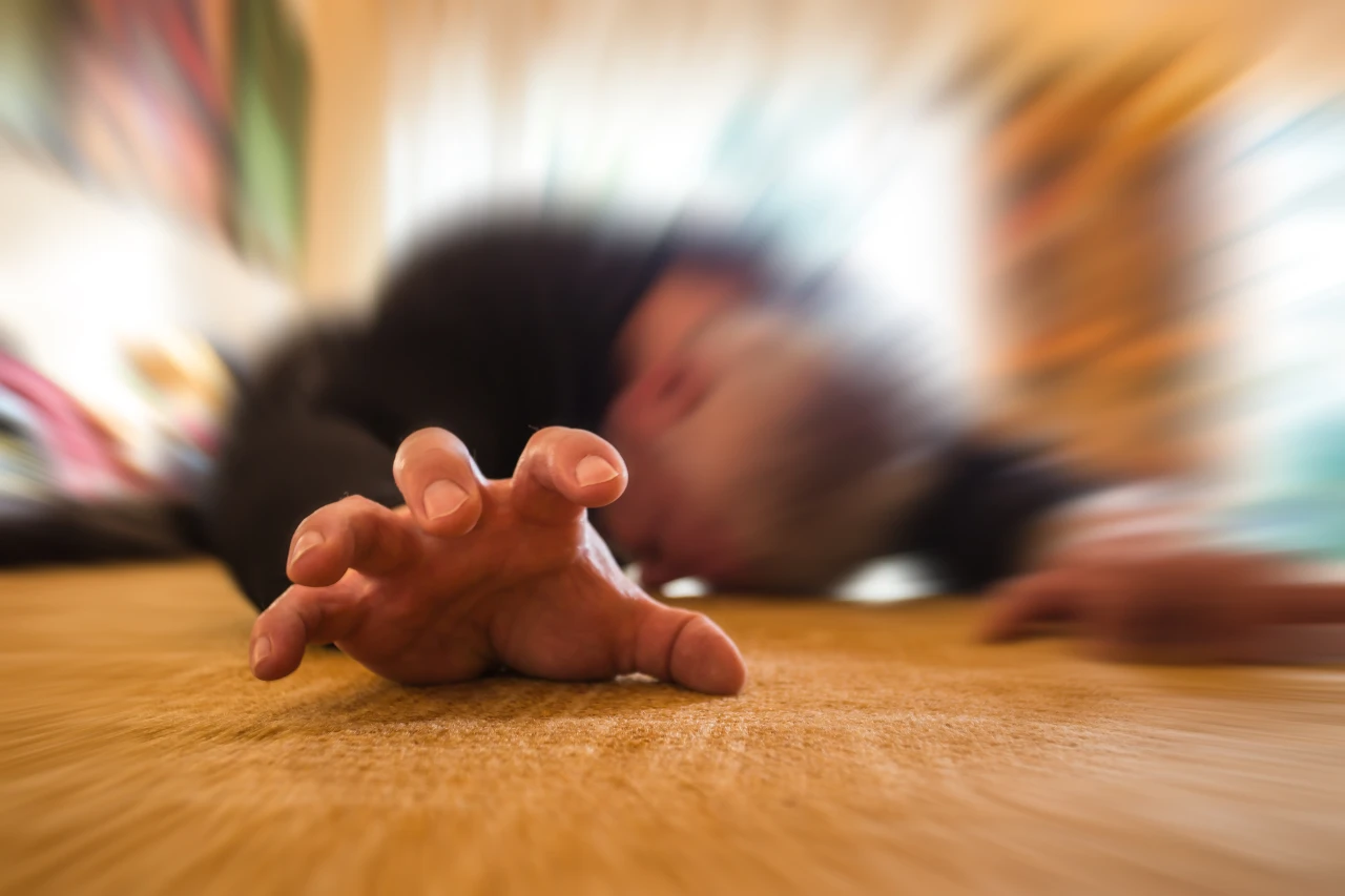 Man ligt op grond met uitgestoken hand en is niet goed geworden door overdosis drugs.