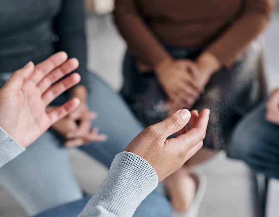 Mensen zitten samen in gesprek tijdens een groepssessie over verslaving en herstel binnen de verslavingszorg.