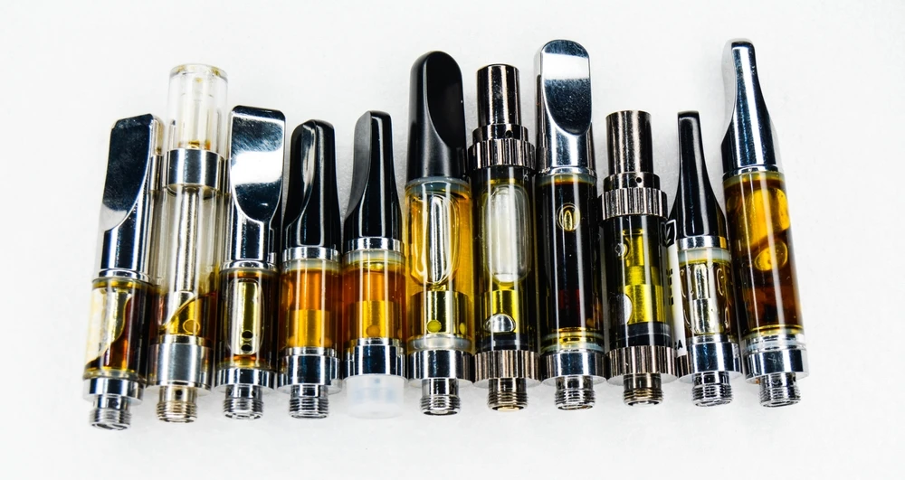 Collectie THC met verschillende mondstukken en goudkleurige olie.