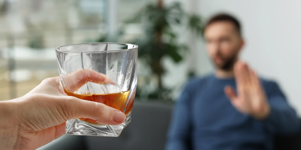 Een persoon weigert een glas alcohol tijdens het herstel van alcoholgebruik.
