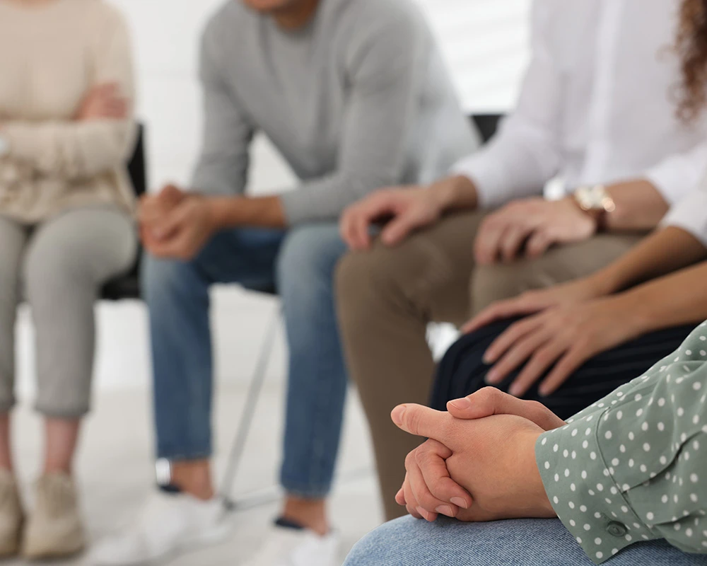 Mensen zitten samen in een groepssessie binnen een voorzorg traject voor verslavingszorg en ondersteuning.