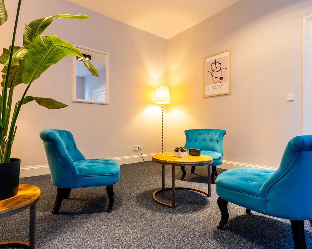 Een rustige zithoek met stoel, tafel en tissues binnen een afkickkliniek in Utrecht.